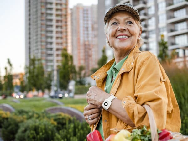 Woman at farmers marketing wearing Medical Alert Mini Mobile System