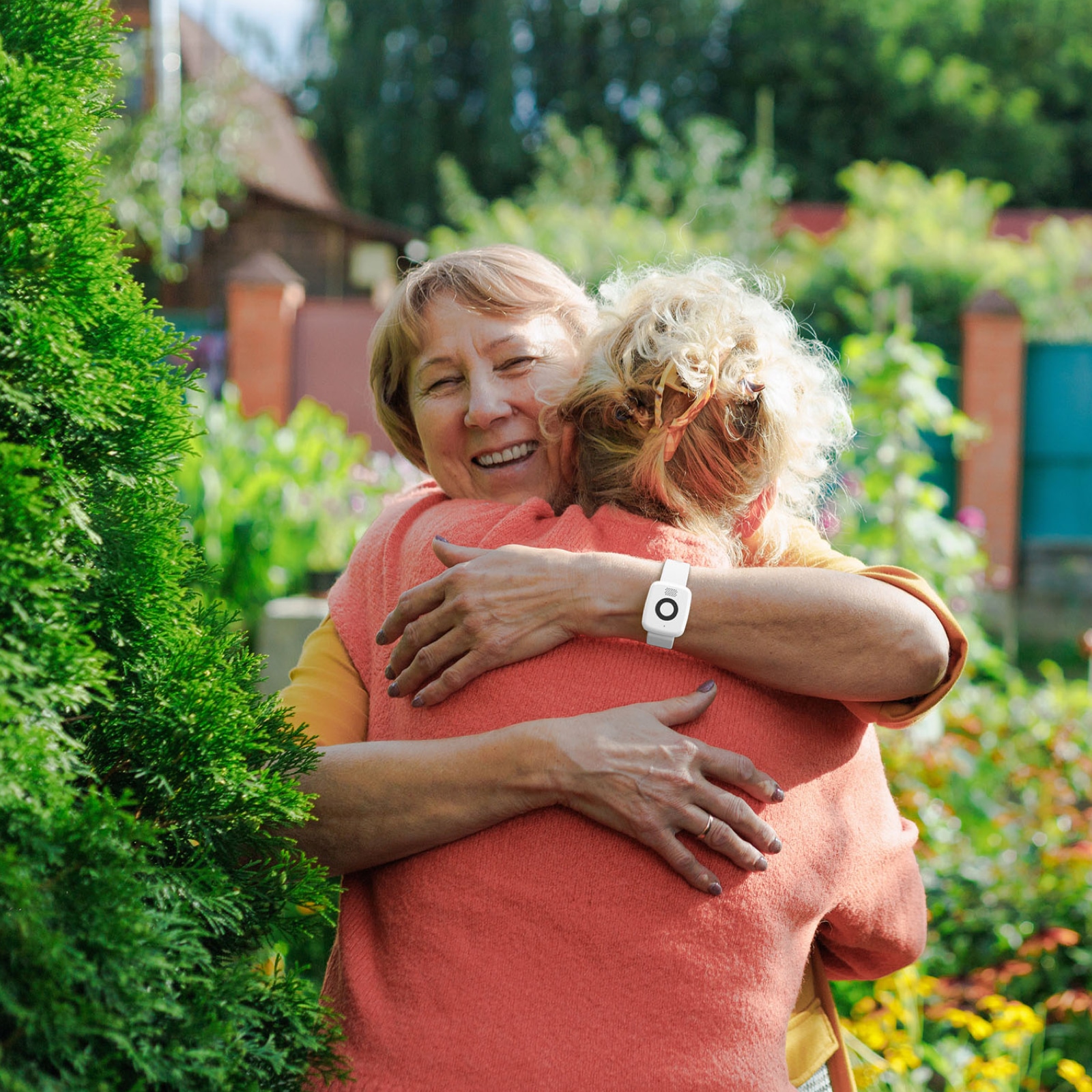 Woman wearing Medical Alert Mini Mobile System hugs a friend