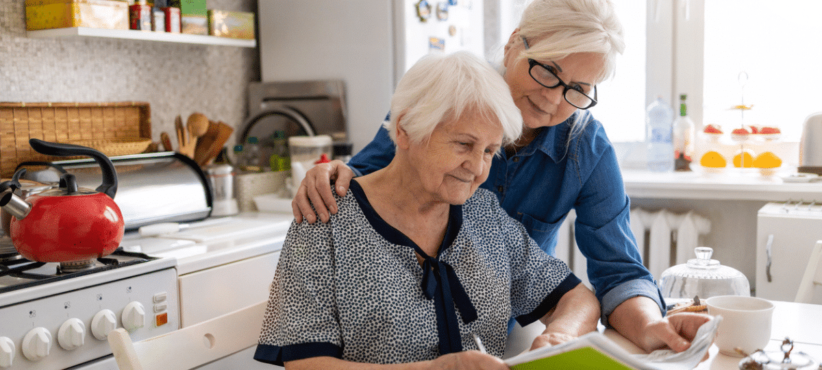 Mature Woman Helping Elderly Mother With Paperwork